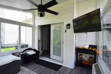 Interior of a sunroom featuring a TV mounted to the wall.